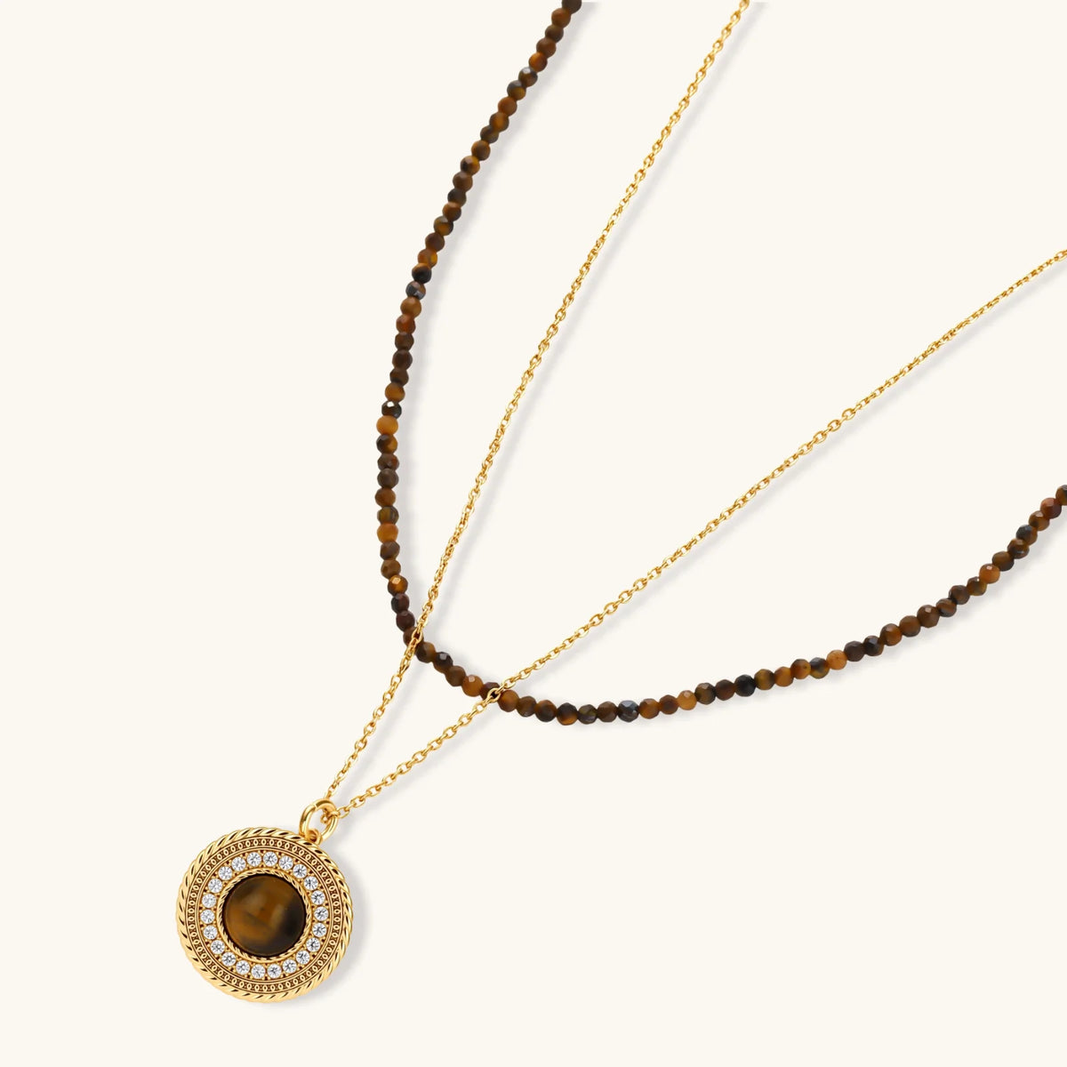 Gold plated eco-brass set with brown cat-eye stone pendant, beaded brown necklace and matching round zirconia halo stud earrings.