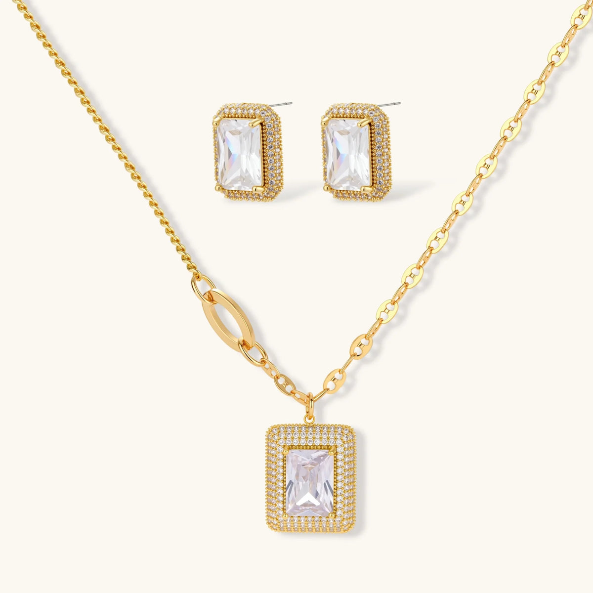 Gold-plated jewelry set with rectangular cubic zirconia stones in pave halo settings on cream background