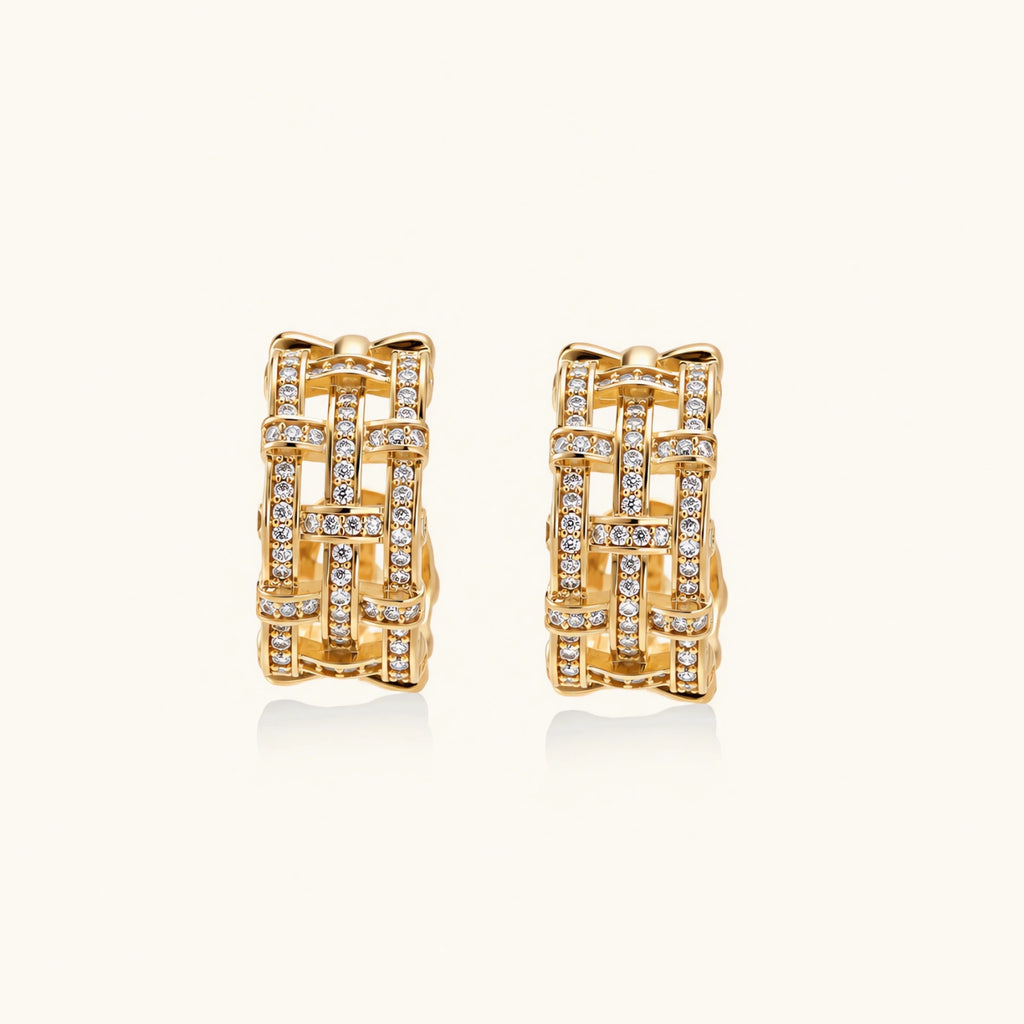 Gold-plated geometric hoop earrings with basket-weave lattice design and pavé crystal accents on cream background