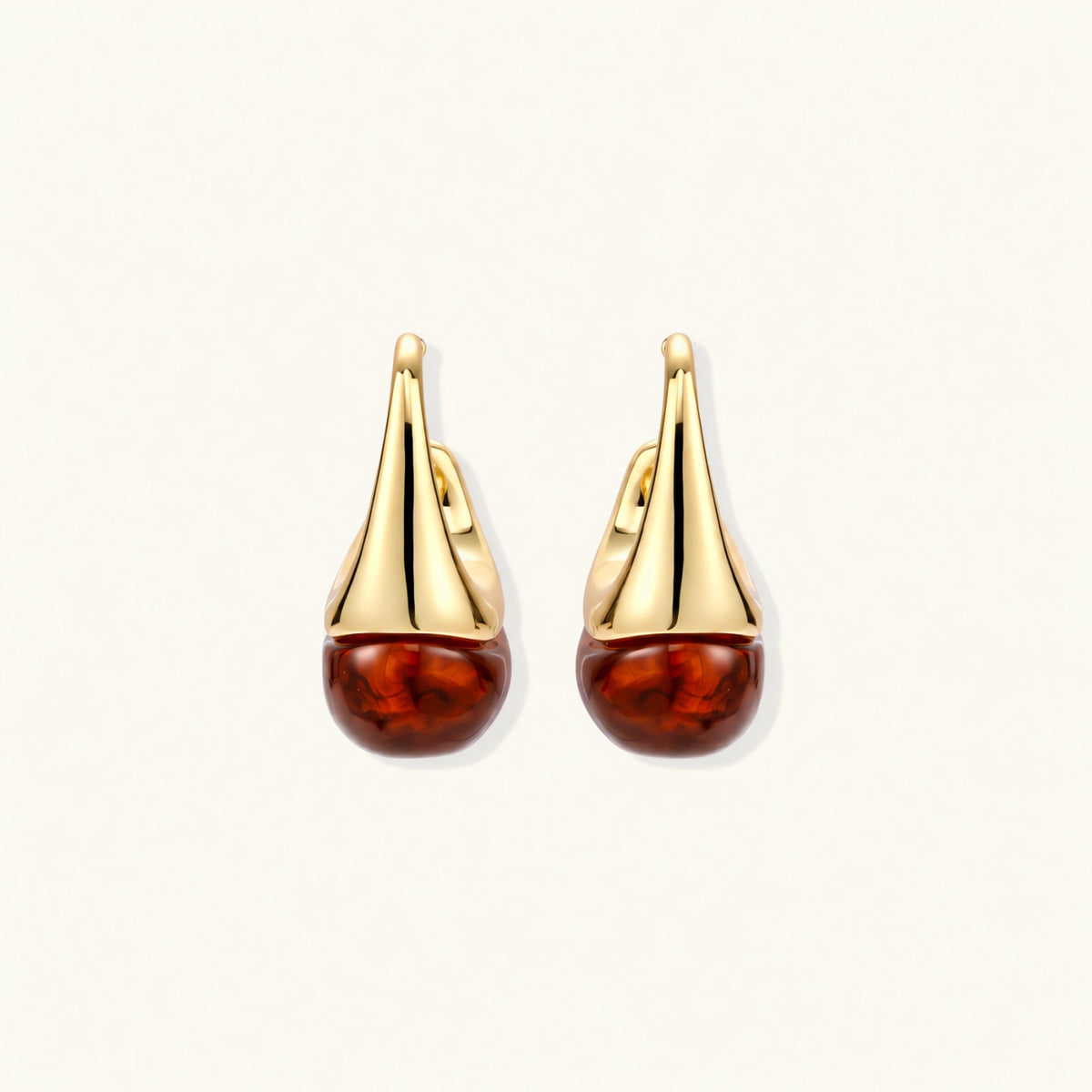 Modern drop earrings with curved gold-plated copper tops and amber resin bottoms creating an organic teardrop silhouette.