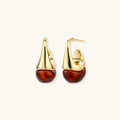 Modern drop earrings with curved gold-plated copper tops and amber resin bottoms creating an organic teardrop silhouette.