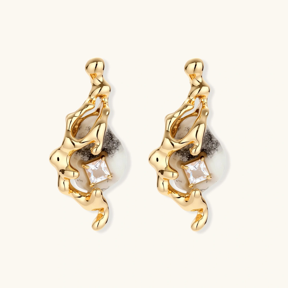 Gold-toned dangle earrings with marbled resin stones and flowing serpentine chain design on neutral background