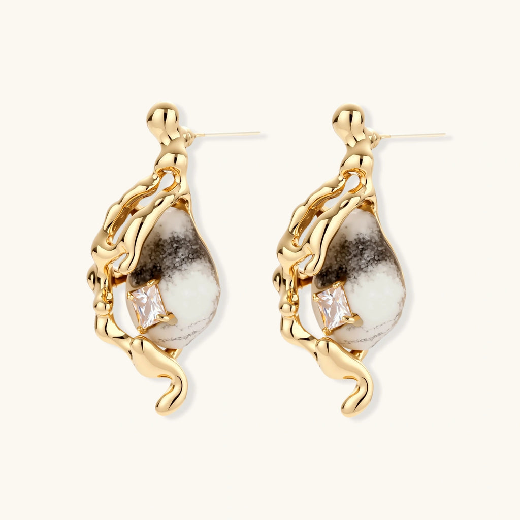 Gold-toned dangle earrings with marbled resin stones and flowing serpentine chain design on neutral background