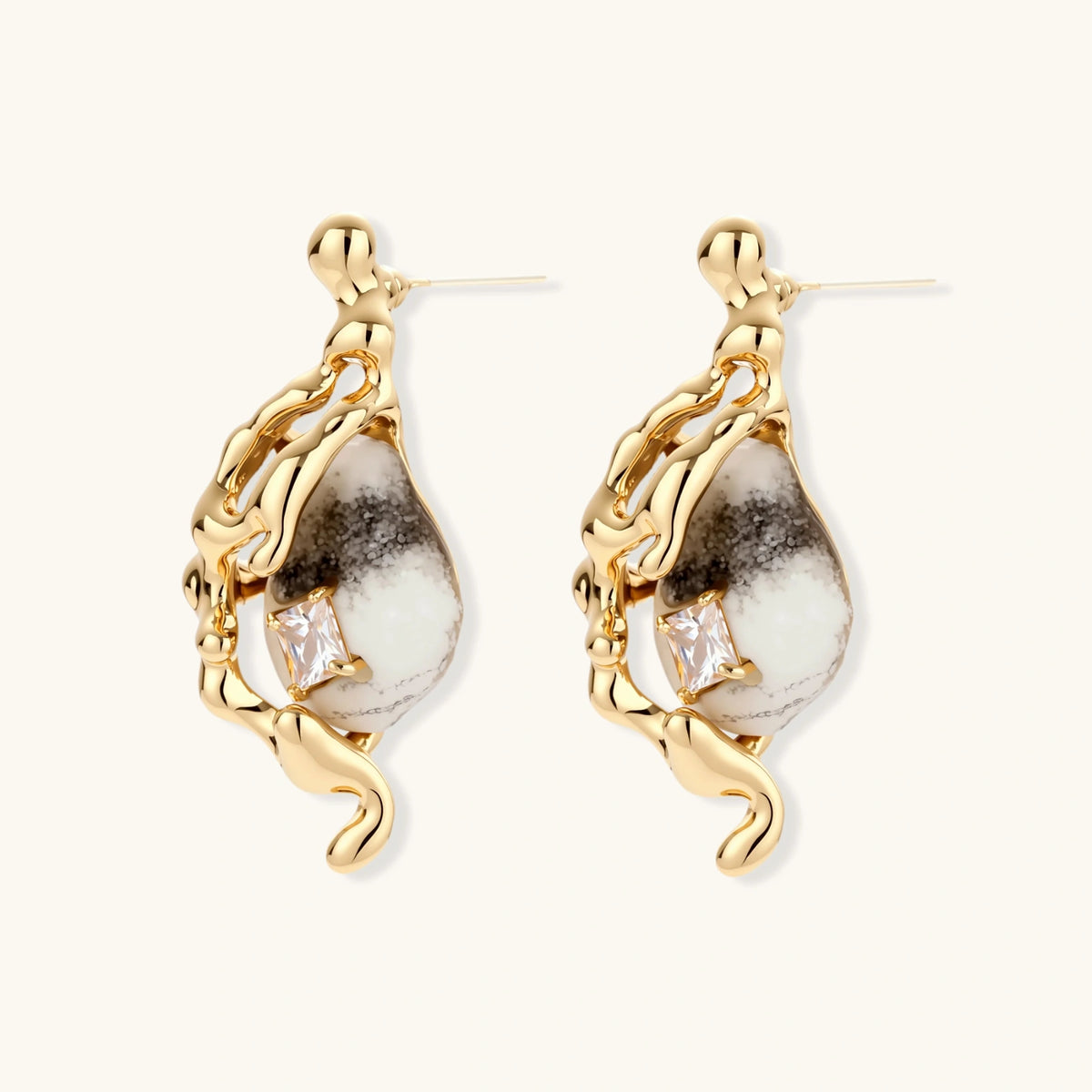 Gold-toned dangle earrings with marbled resin stones and flowing serpentine chain design on neutral background